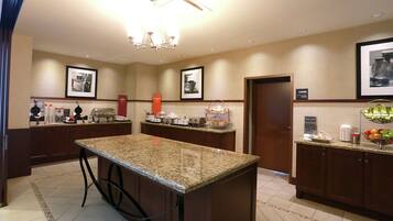 A hotel kitchen with granite countertops, stainless steel appliances, and a central island.