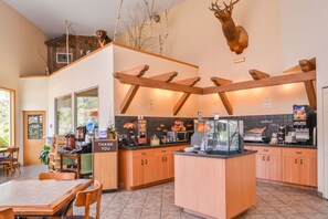 A modern kitchen with wooden cabinets, a central island, and a mounted deer head on the wall.