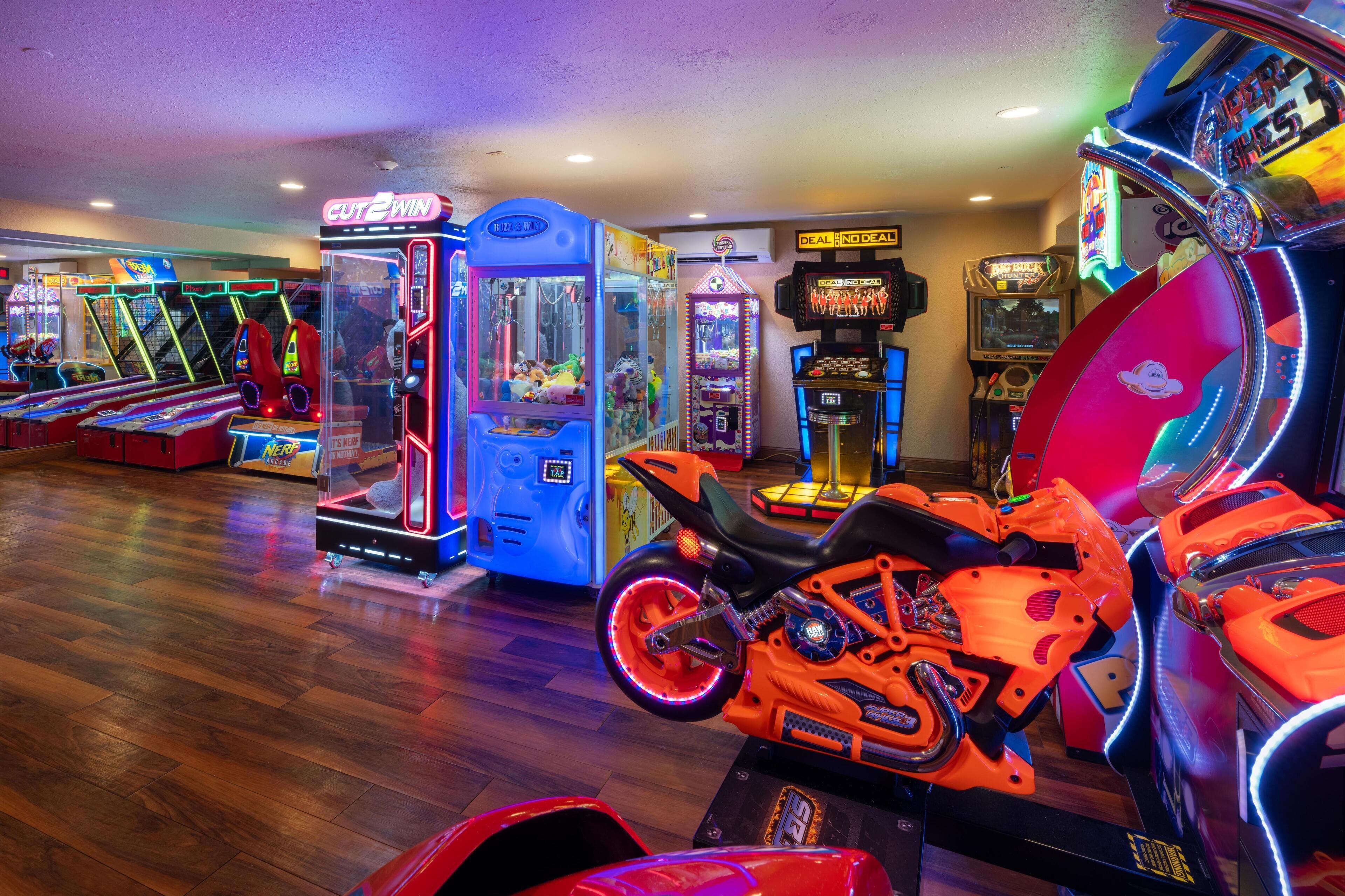 An indoor arcade with claw machines and racing game machines.