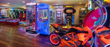 An indoor arcade with claw machines and racing game machines.
