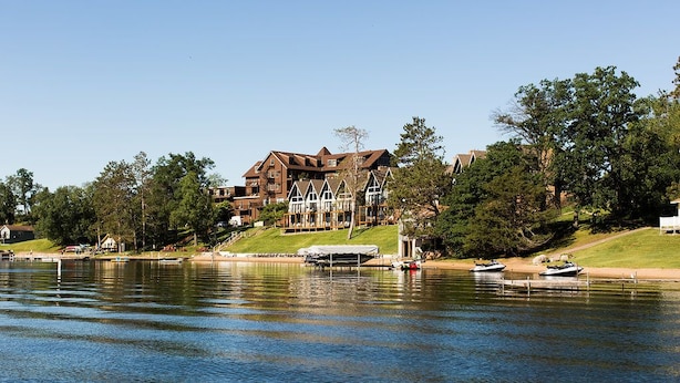 A lakeside property with a large house, dock, and boats. - Maddens On Gull Lake (Brainerd)