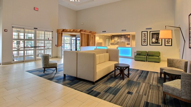 A spacious lobby with a reception desk, seating area, and a large window with a view.
