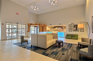 Un vestíbulo amplio con mostrador de recepción, zona de estar y un gran ventanal con vistas.