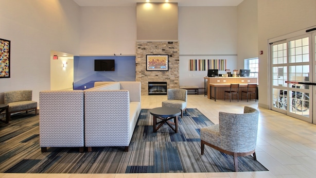 A spacious lobby with a fireplace, seating area, and a reception desk.