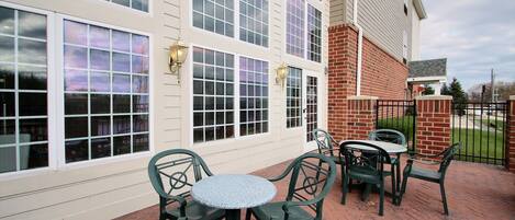 A patio with outdoor seating and large windows.