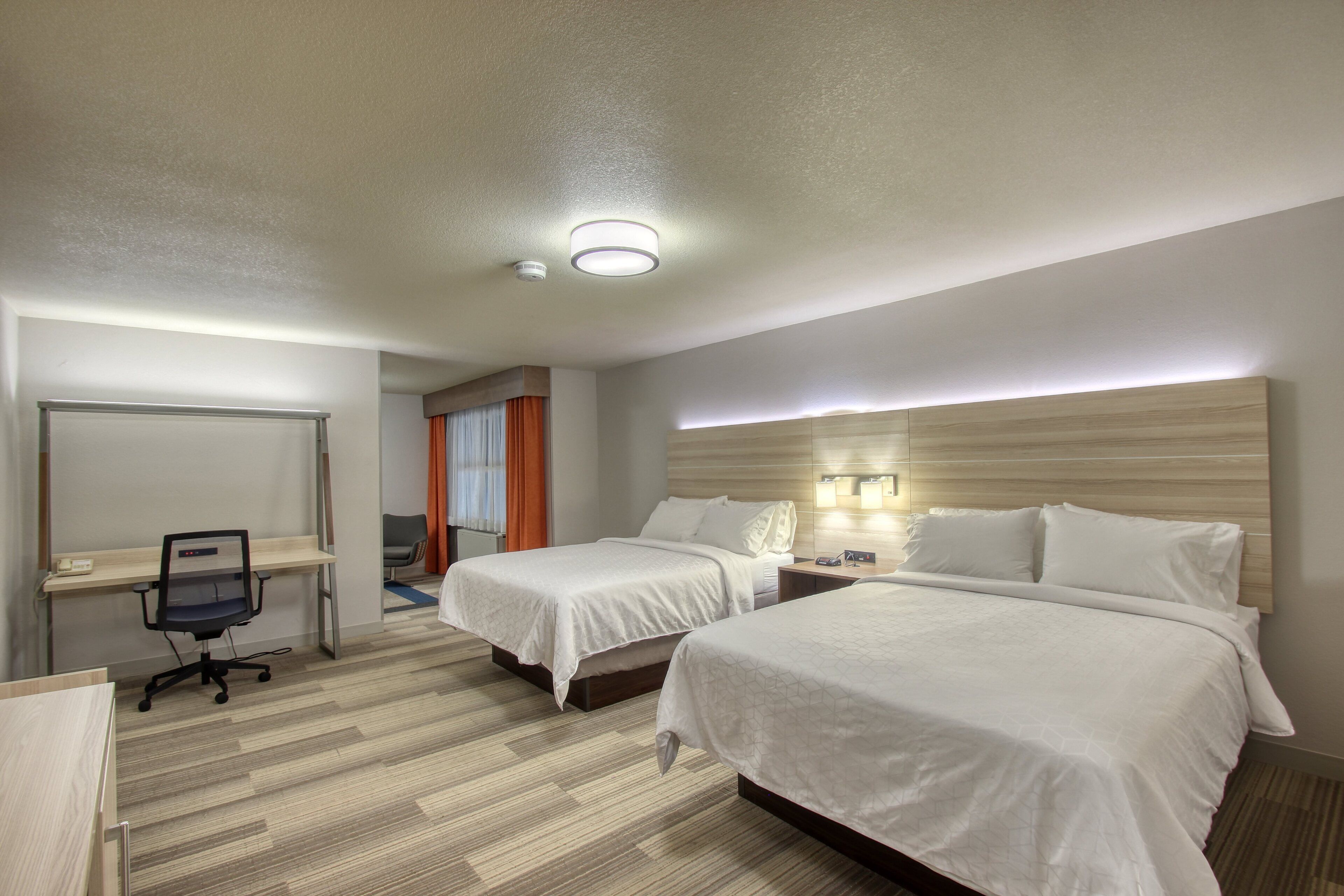 Una habitación de hotel con dos camas, un escritorio y una silla.