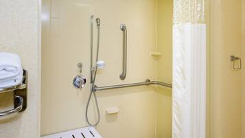 A bathroom with a shower, grab bars, a white towel rack, and a white shower curtain.