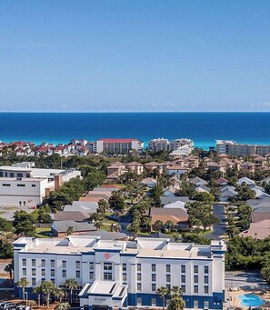 Un hôtel situé sur la côte, composé de plusieurs bâtiments, doté d’une piscine et offrant une vue sur l’océan.