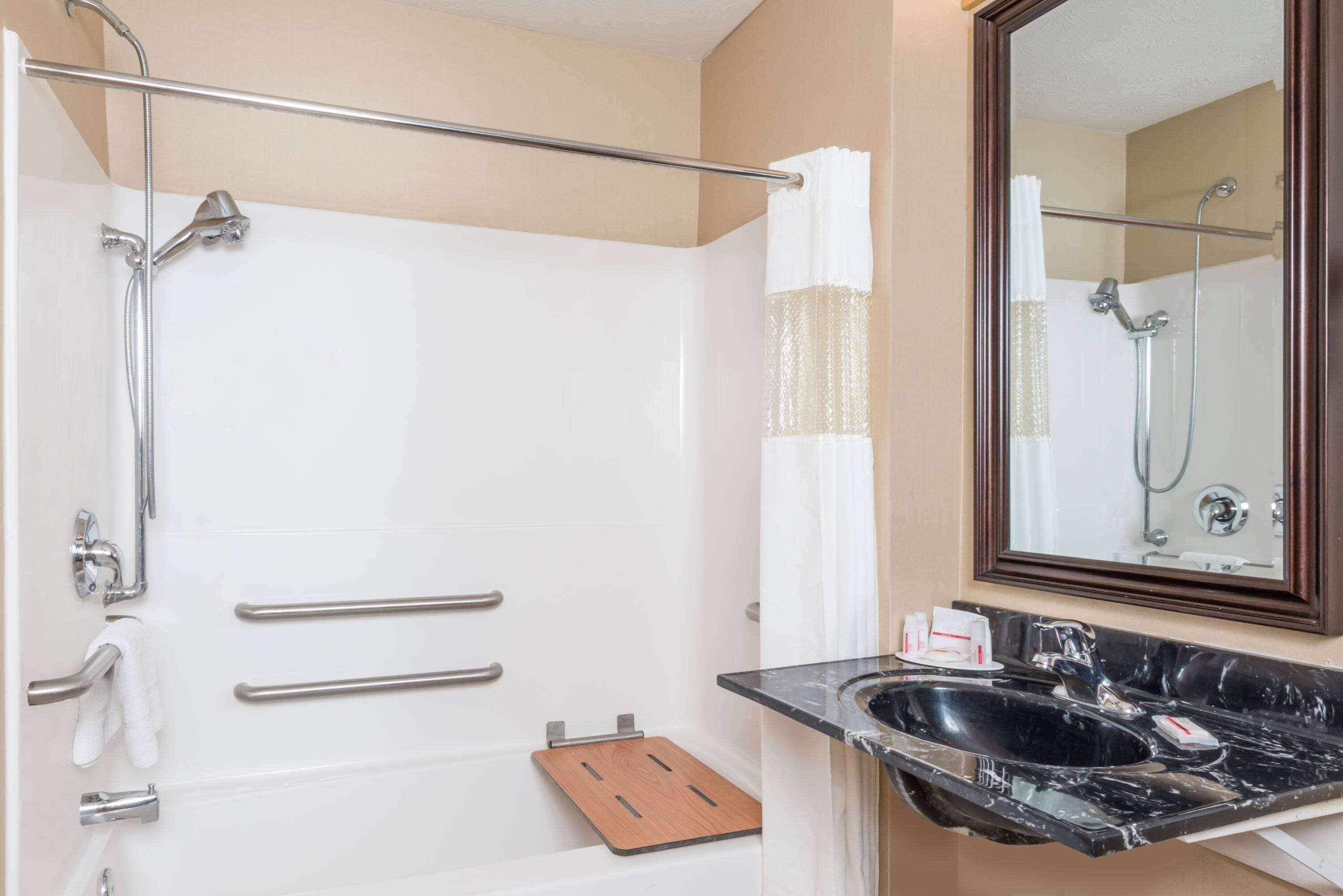 A modern bathroom with a bathtub, shower, and a vanity with a sink.