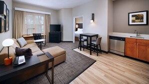 Una habitación de hotel moderna con sala de estar, comedor y kitchenette.