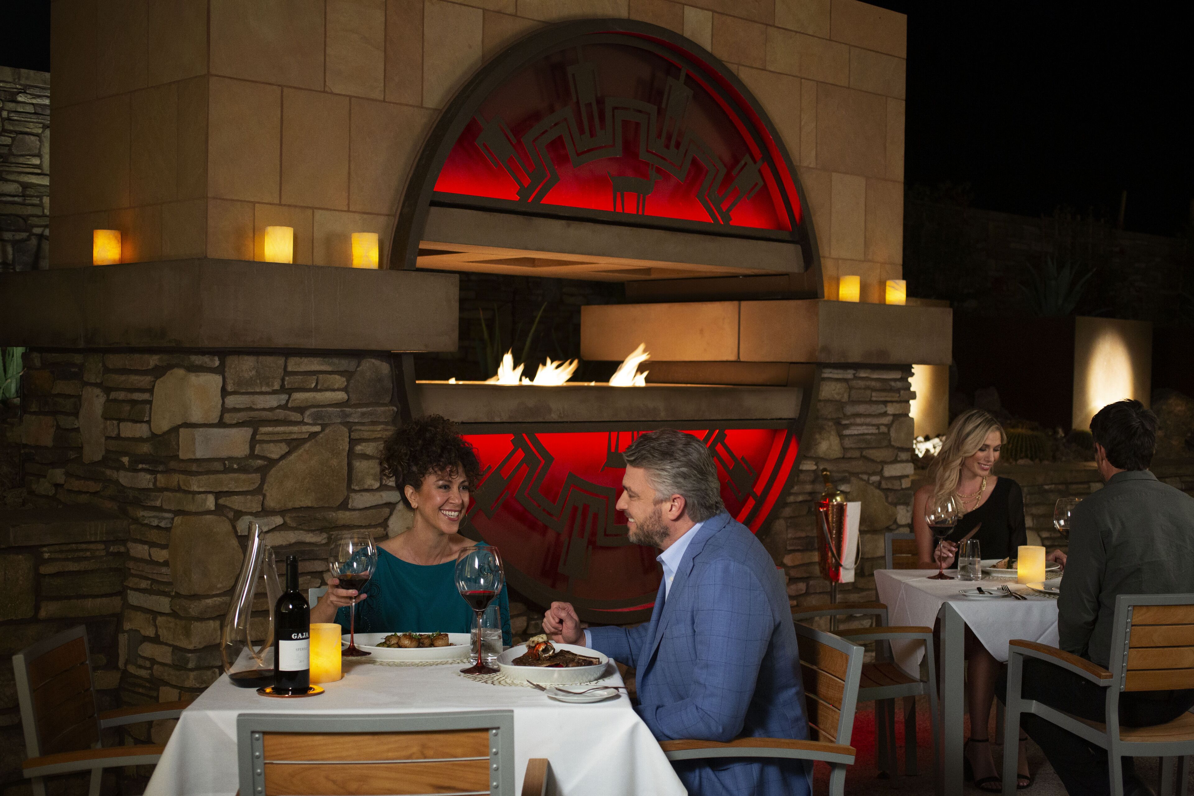 A restaurant with stone walls and a fire feature in the center.