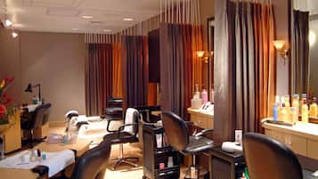 Experience a professional atmosphere in this well-appointed salon with hair styling chairs, a large mirror, and a counter with hair care products.