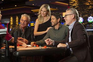 Um grupo de pessoas jogando cartas em uma mesa de cassino.