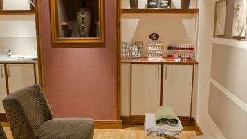 Relax in a serene spa room with a seating area, vanity, and artwork.