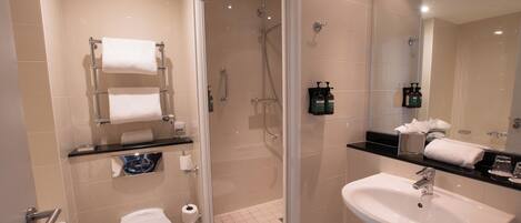 A modern bathroom with a walk-in shower, a toilet, and a sink.