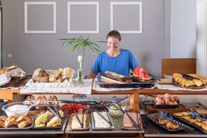 A buffet setup with various food items and utensils. - Bella Vista Beach Hotel and Studios (Corfu)