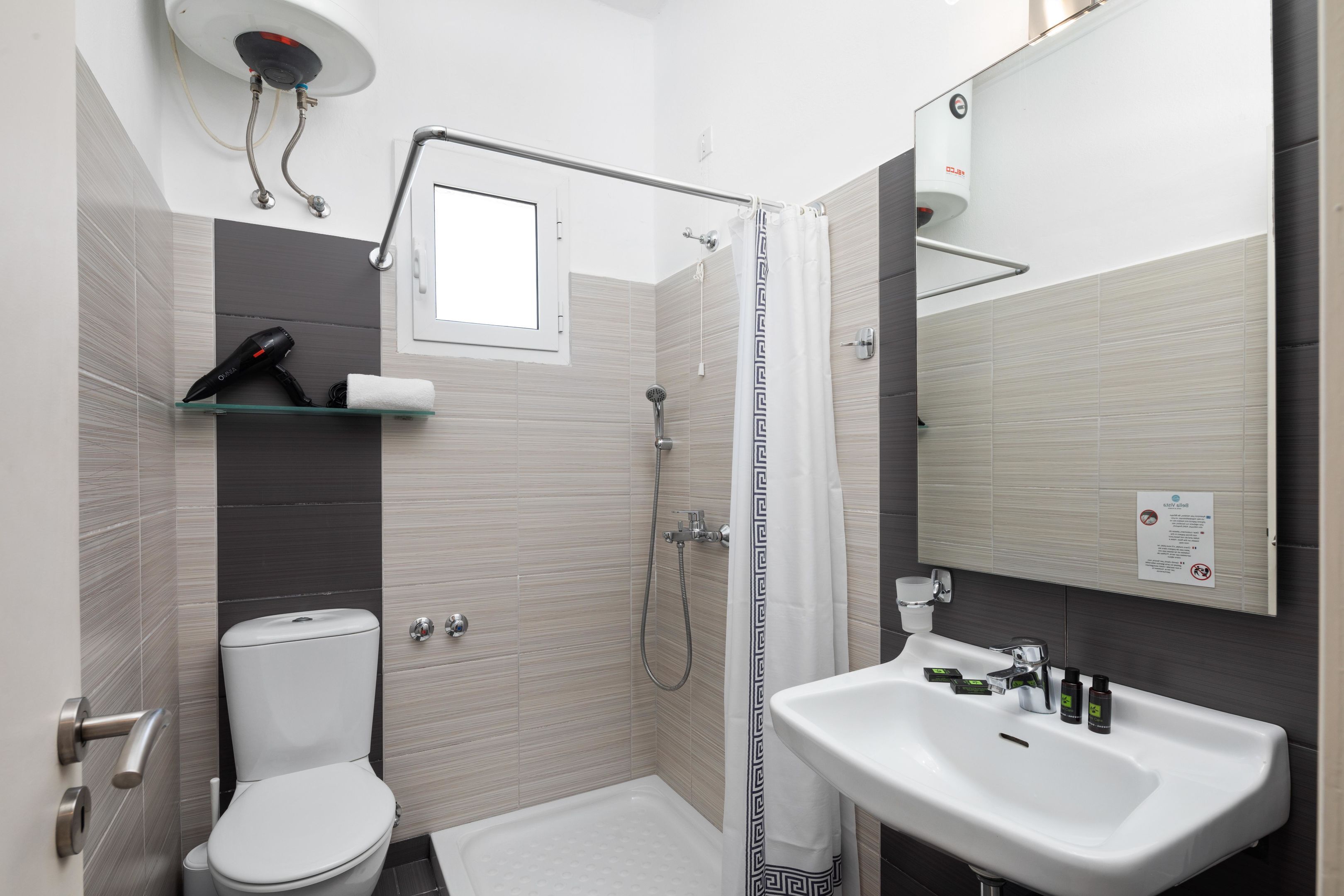 A modern bathroom with a toilet, shower, and sink.