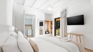 Un dormitorio moderno con una cama grande, un televisor montado en la pared y vistas al exterior.