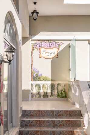 A staircase with a sign reading "Reception" above it, leading to a glass door. - Bella Vista Beach Hotel and Studios (Corfu)