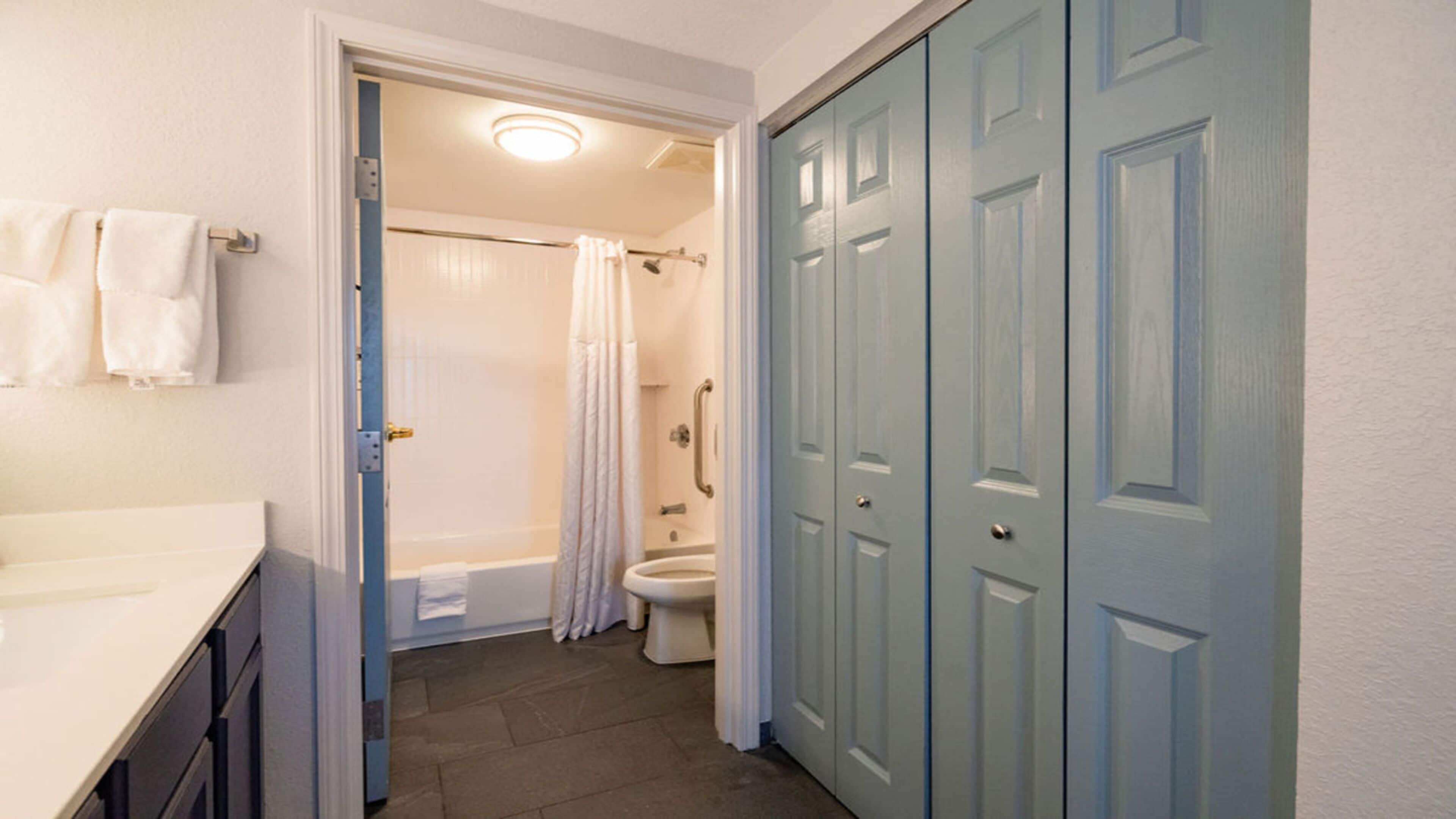 A bathroom with a shower, toilet, and a sink.