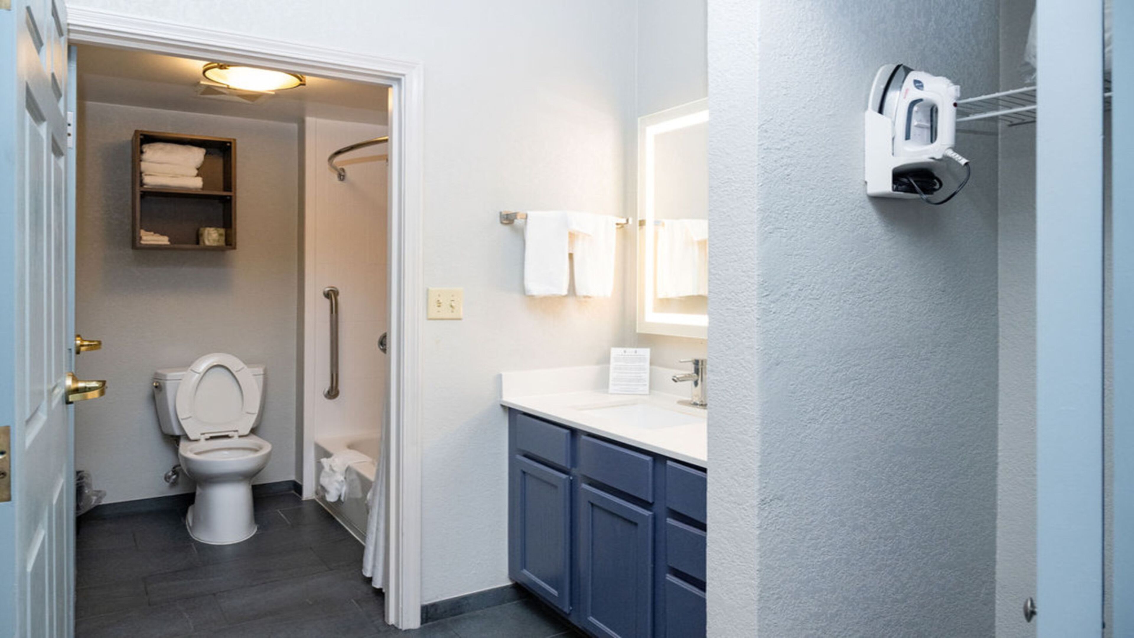 A bathroom with a toilet, shower, and sink.