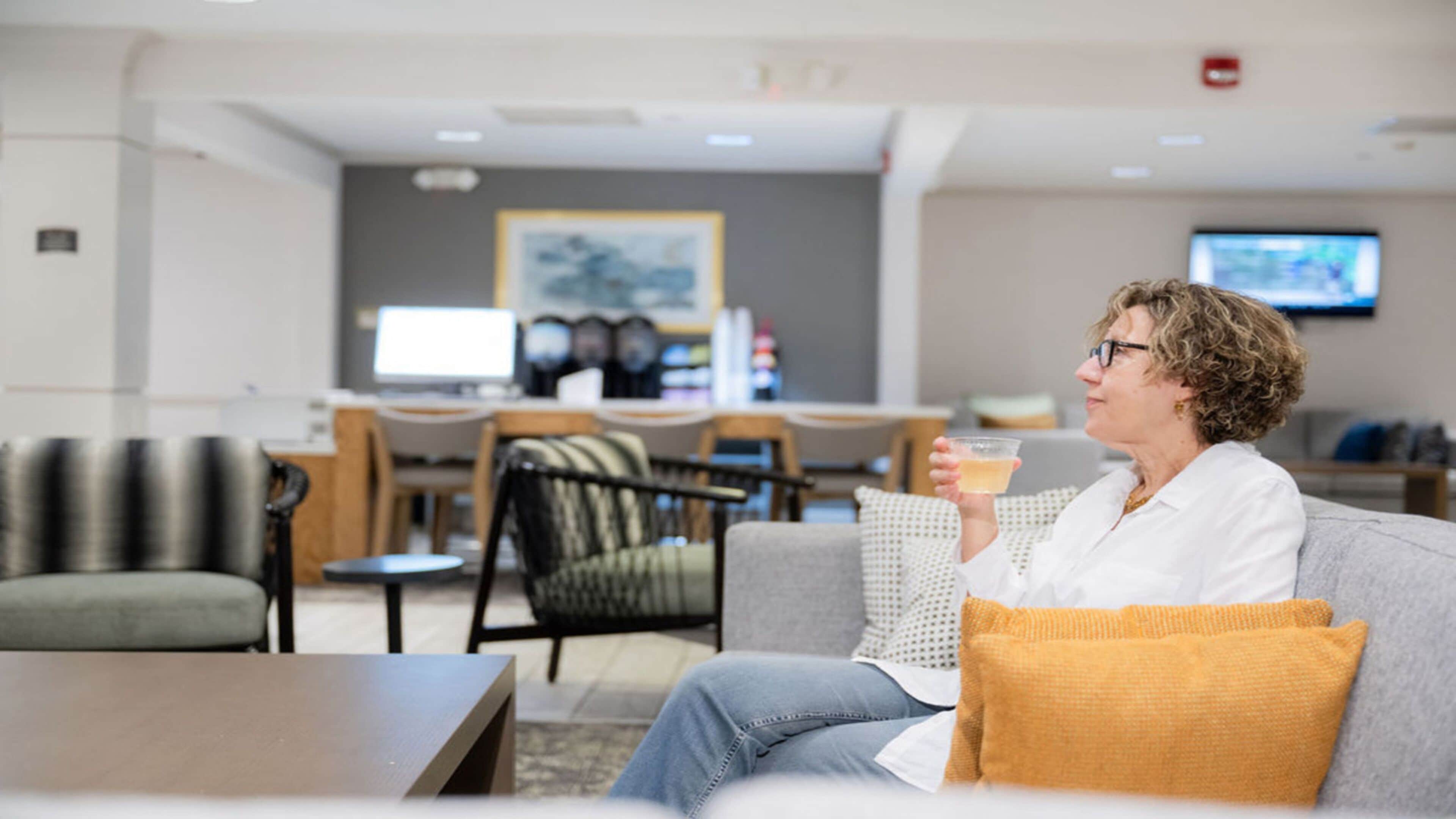A modern lounge area with seating, a coffee machine, and a television.