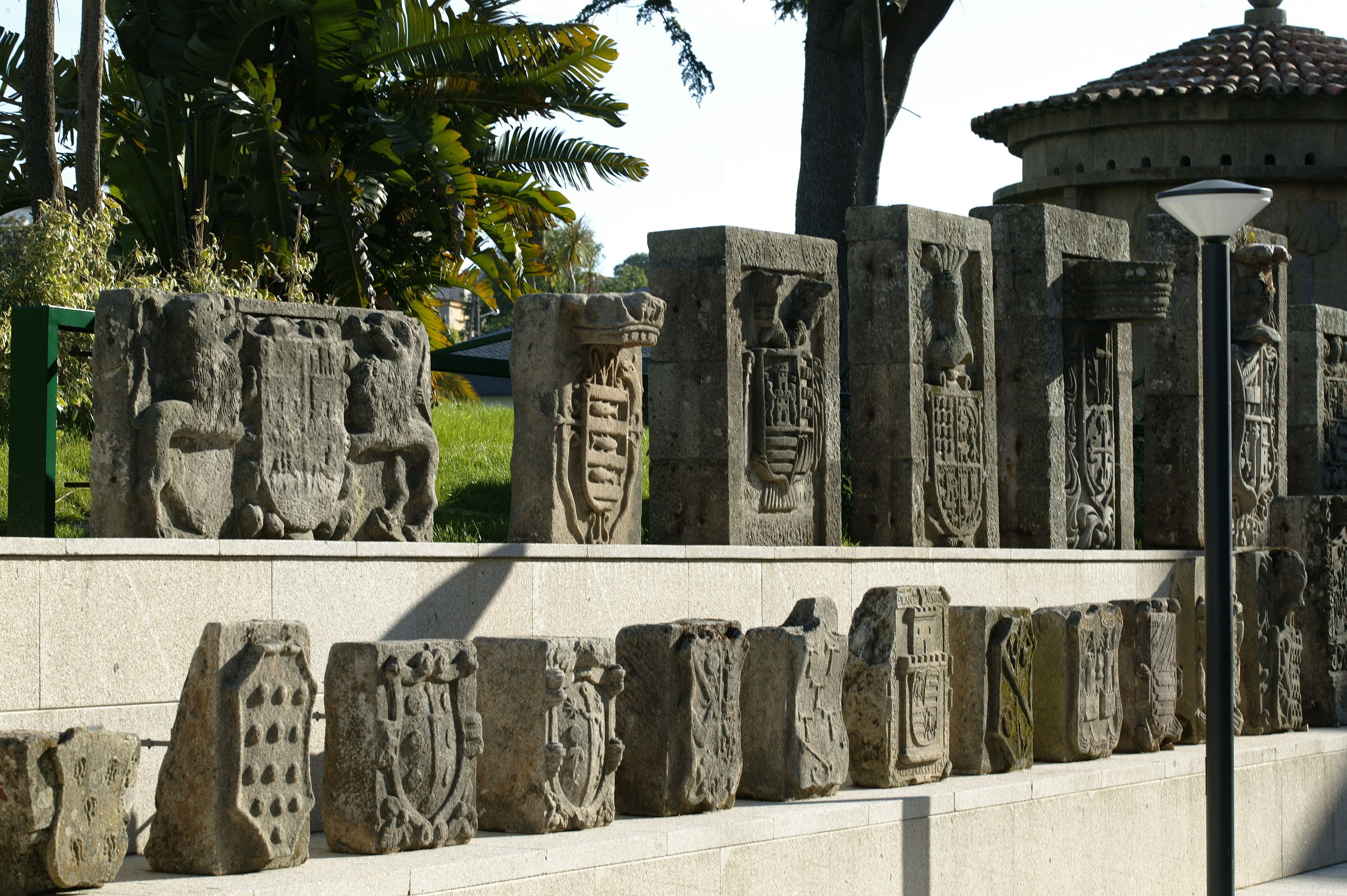 Une série de sculptures sur pierre aux motifs complexes, qui pourraient avoir une signification historique ou culturelle, et qui sont exposées en plein air.