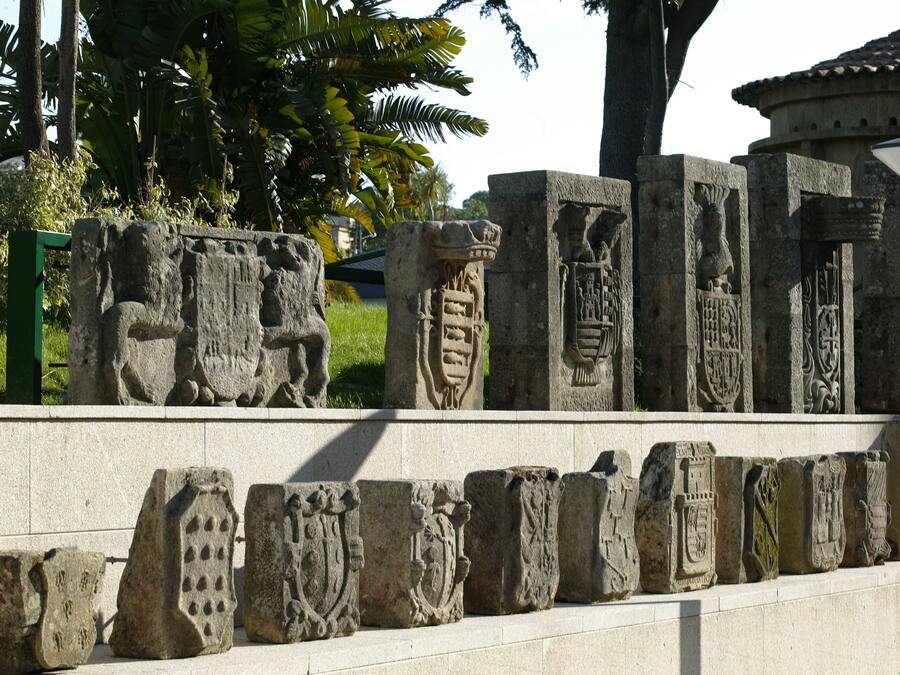 Une série de sculptures sur pierre aux motifs complexes, qui pourraient avoir une signification historique ou culturelle, et qui sont exposées en plein air.