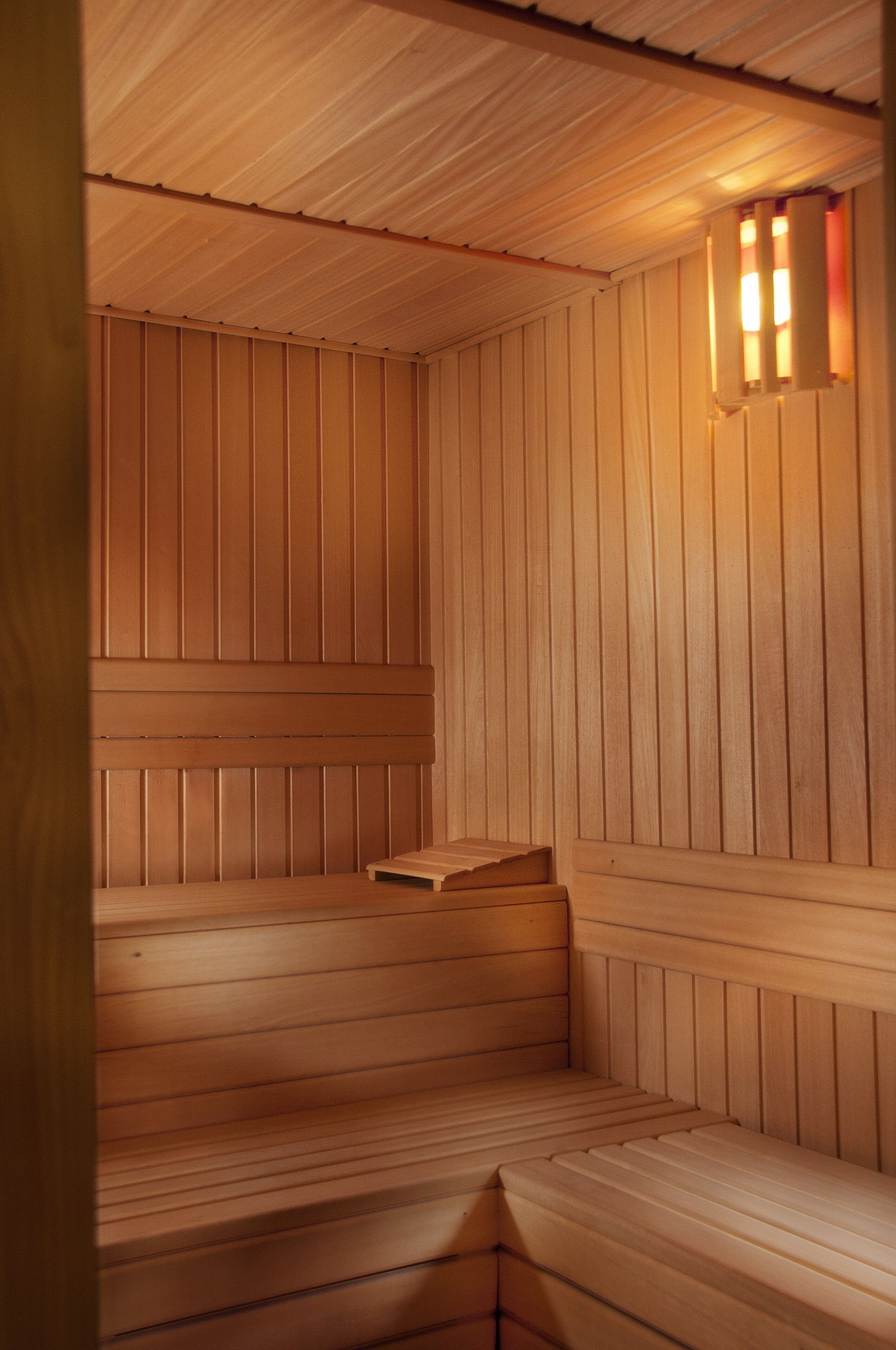Een sauna met houten banken en een schuin dak.