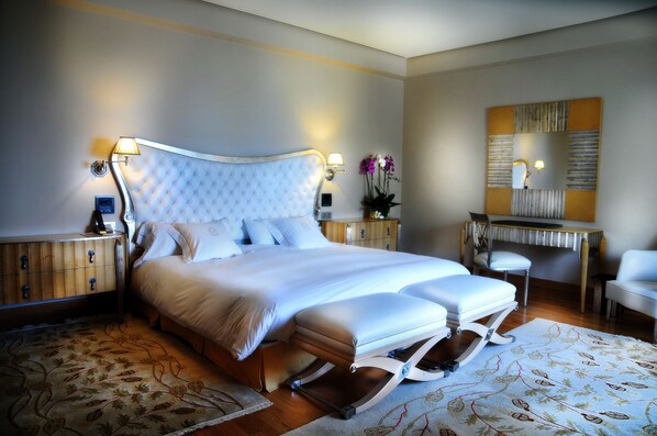 A spacious bedroom with a large bed, a desk, and a chair.