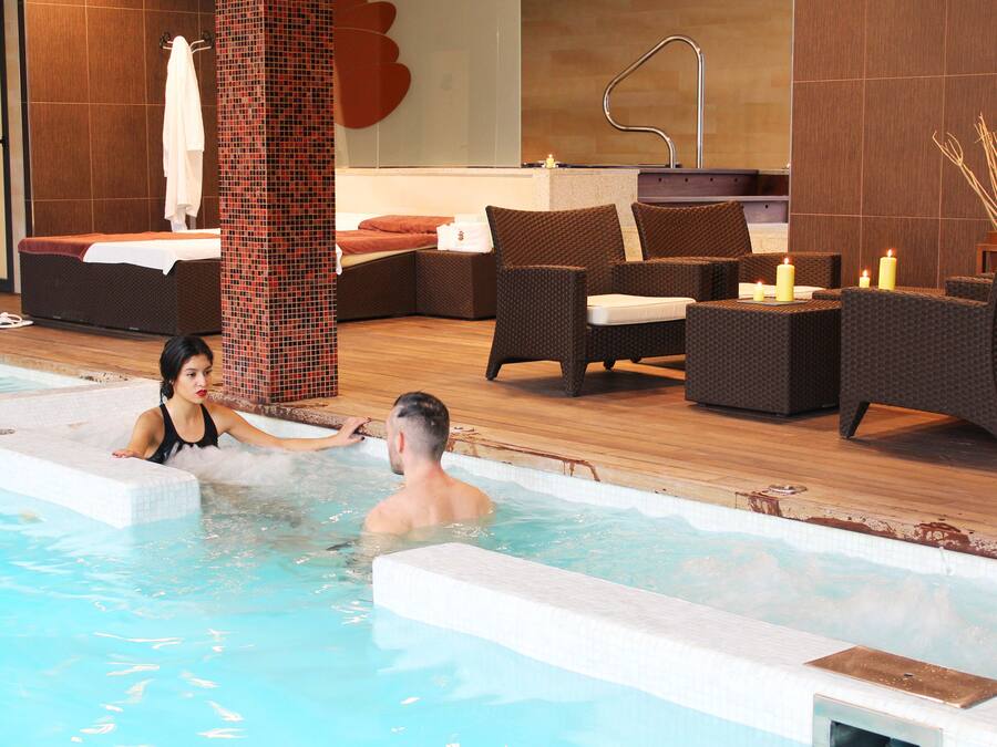 Zona de piscina con sillones de descanso y un espacio para sentarse.