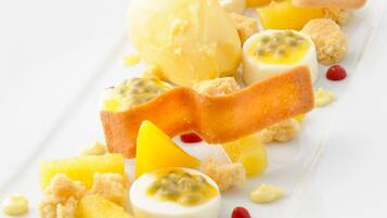 A dessert plate with various fruits and a scoop of ice cream.