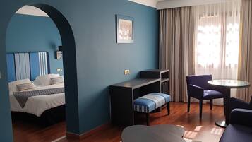 Een moderne hotelkamer met een bed, een bureau, een stoel en een bank.