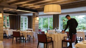 Un restaurant avec plusieurs tables, des chaises et un serveur.