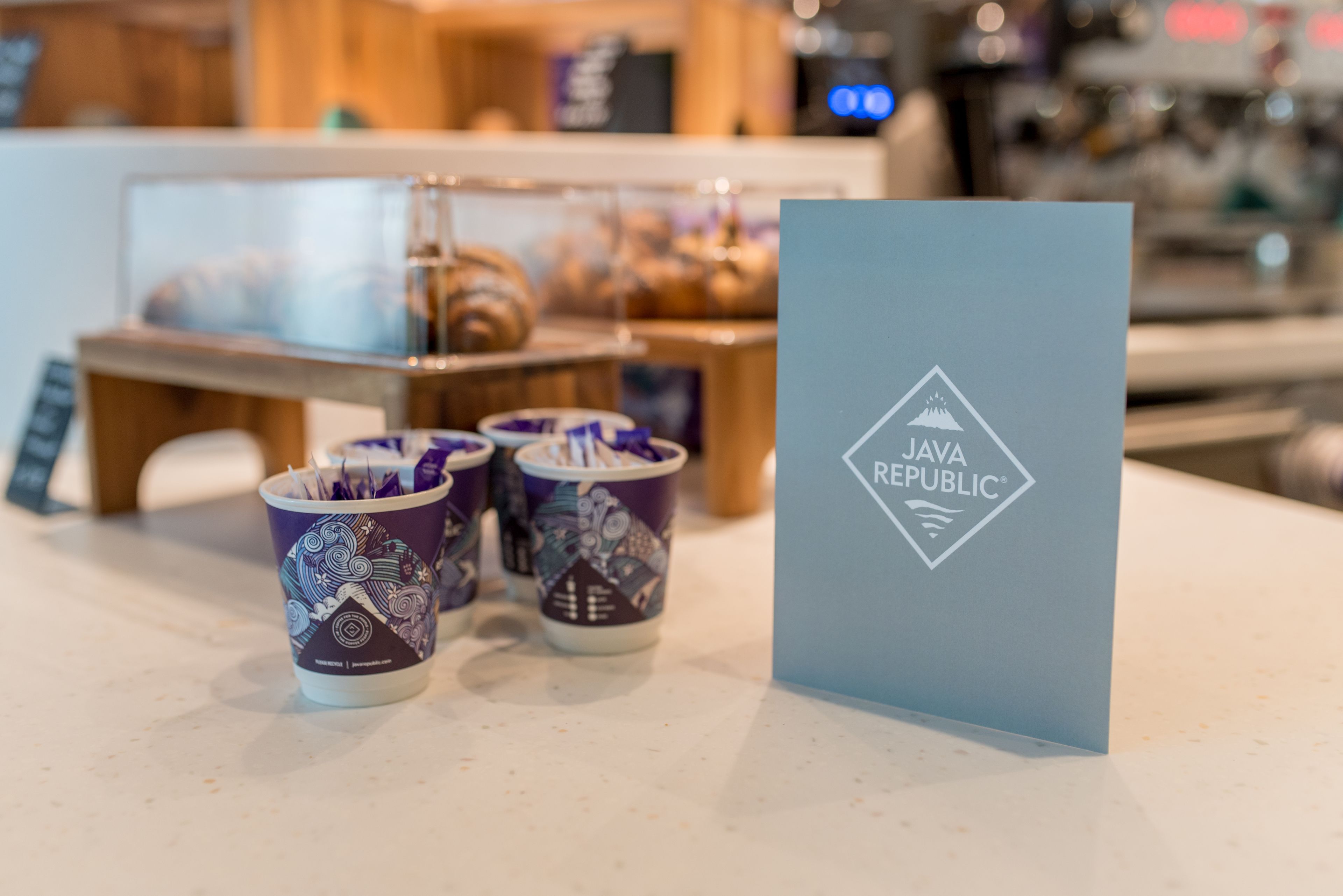 A table with a blue card displaying the Java Republic logo and three patterned cups.