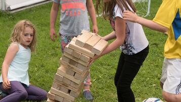 Children playing with wooden blocks on grass.