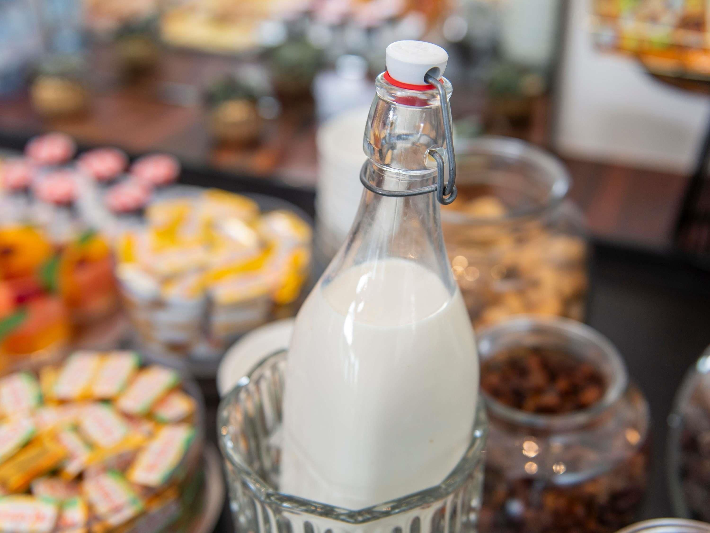 A glass bottle with a metal clasp, surrounded by various food items.