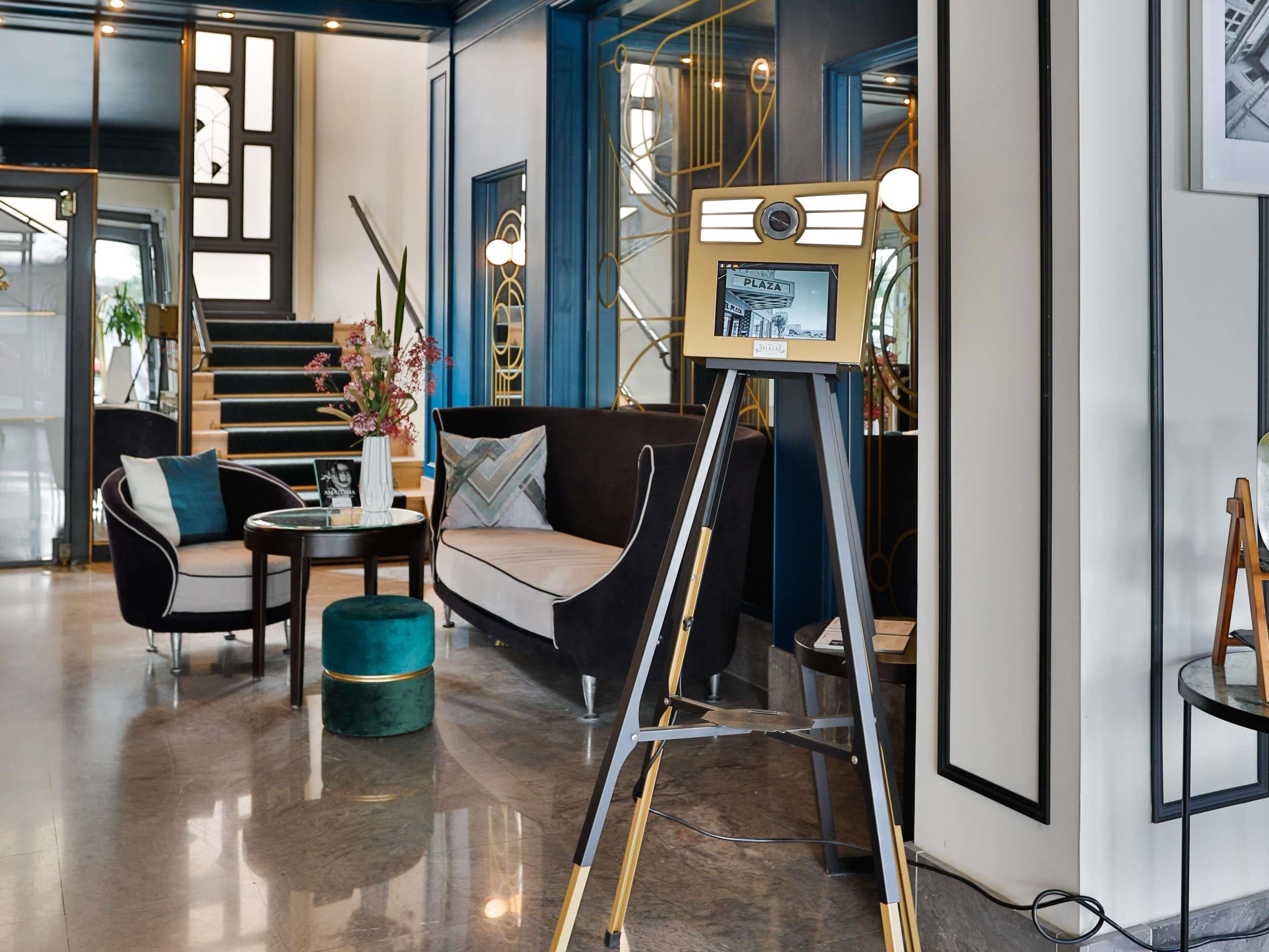 A modern interior with a sofa, armchair, and a small table with a vase of flowers.