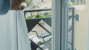 A view from a window overlooking a beach with people and a casino in the background.