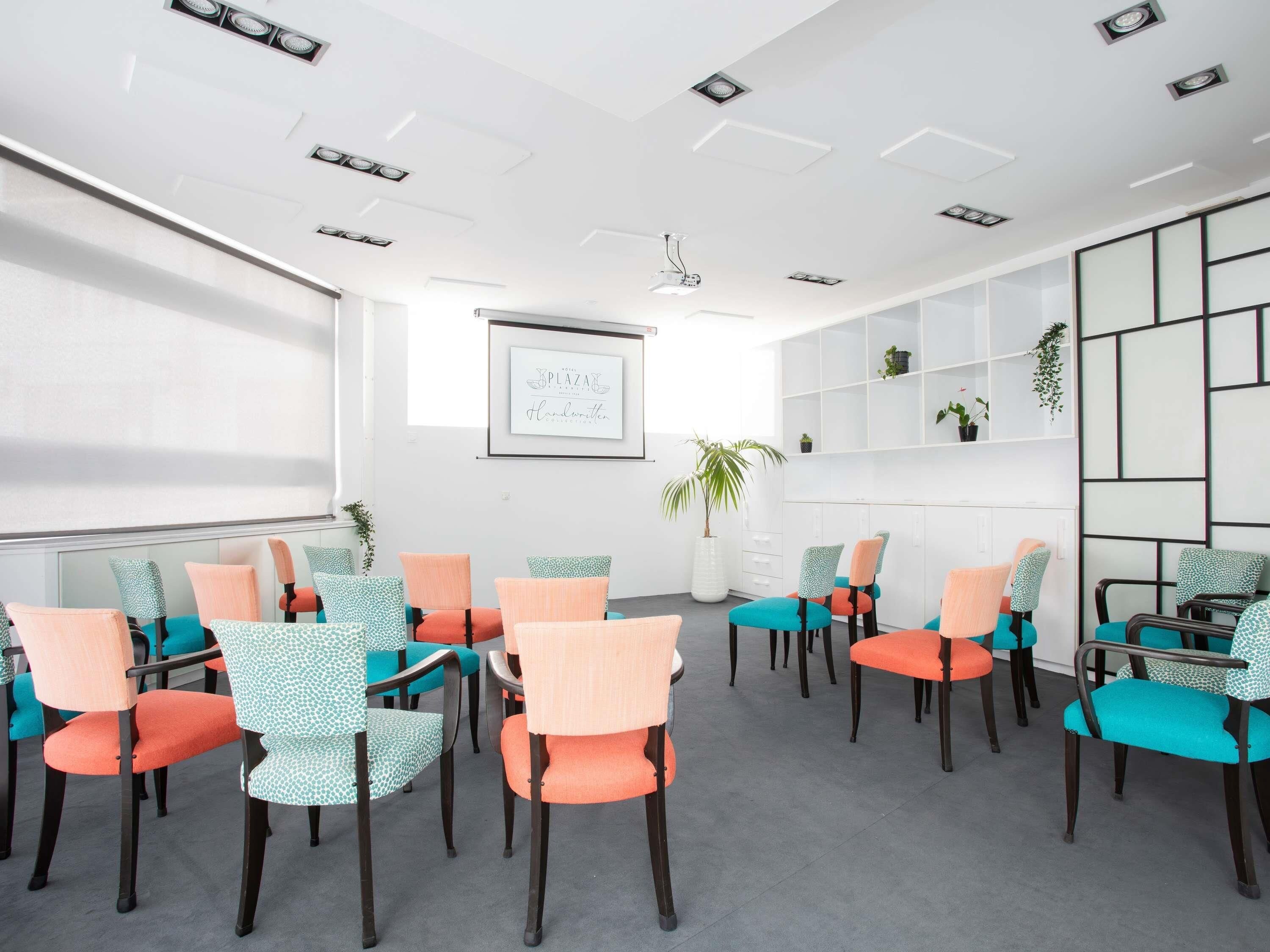 A conference room with a whiteboard, projector, and a framed quote on the wall.