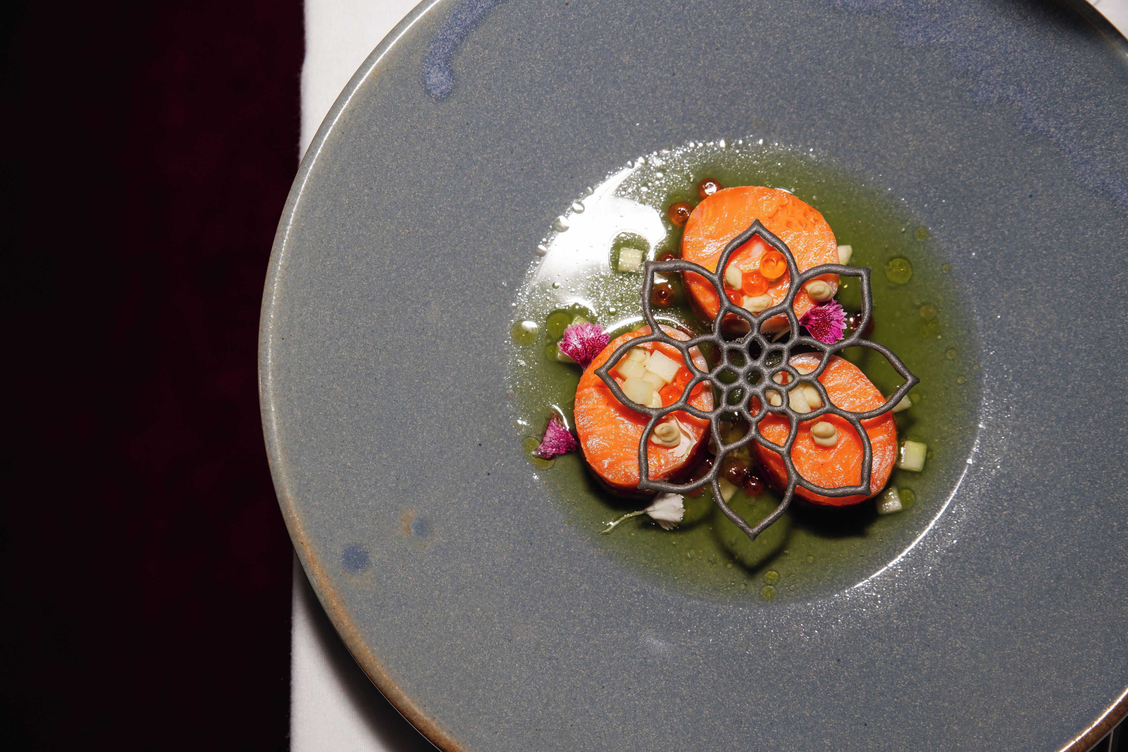 A plate with a decorative arrangement of food, including carrot slices and a decorative element resembling a spider web.