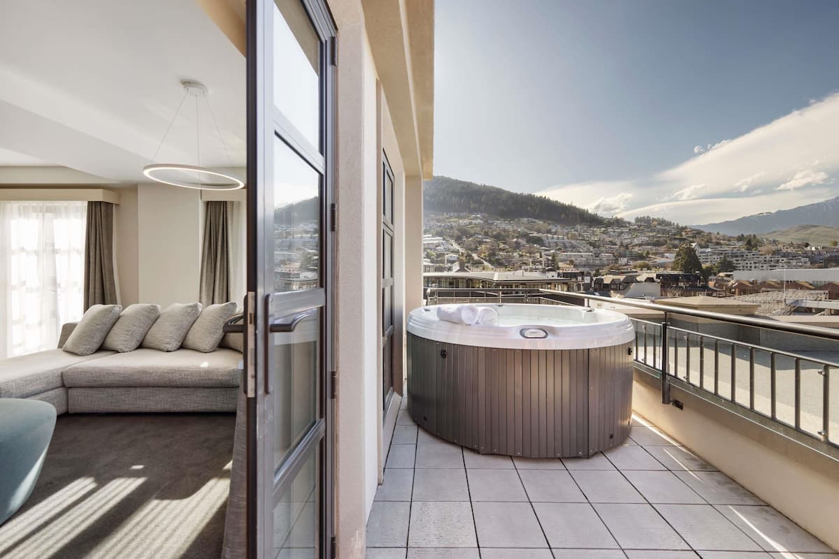 A balcony with a hot tub, a sofa, and a city view.