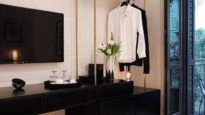 A modern bathroom with a black vanity, a gold-framed mirror, and a white towel hanging on a black hanger. - The Twentyone (Kifisia)