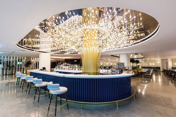 A modern bar area with a unique ceiling design, bar stools, and a seating area with tables and chairs. - Crowne Plaza Belgrade by IHG (Belgrade)