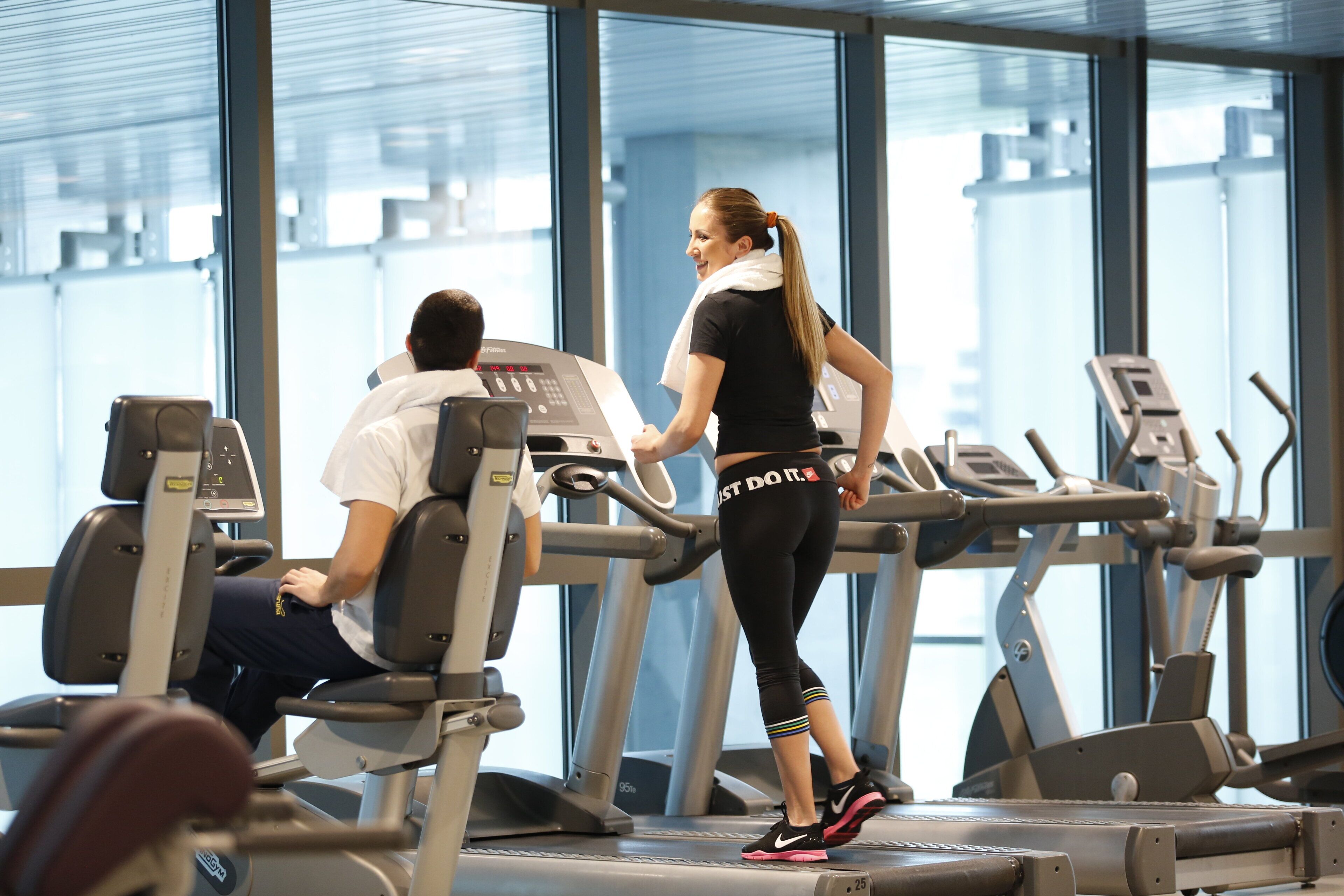 Une salle de sport équipée de tapis de course et d'appareils d'exercice.