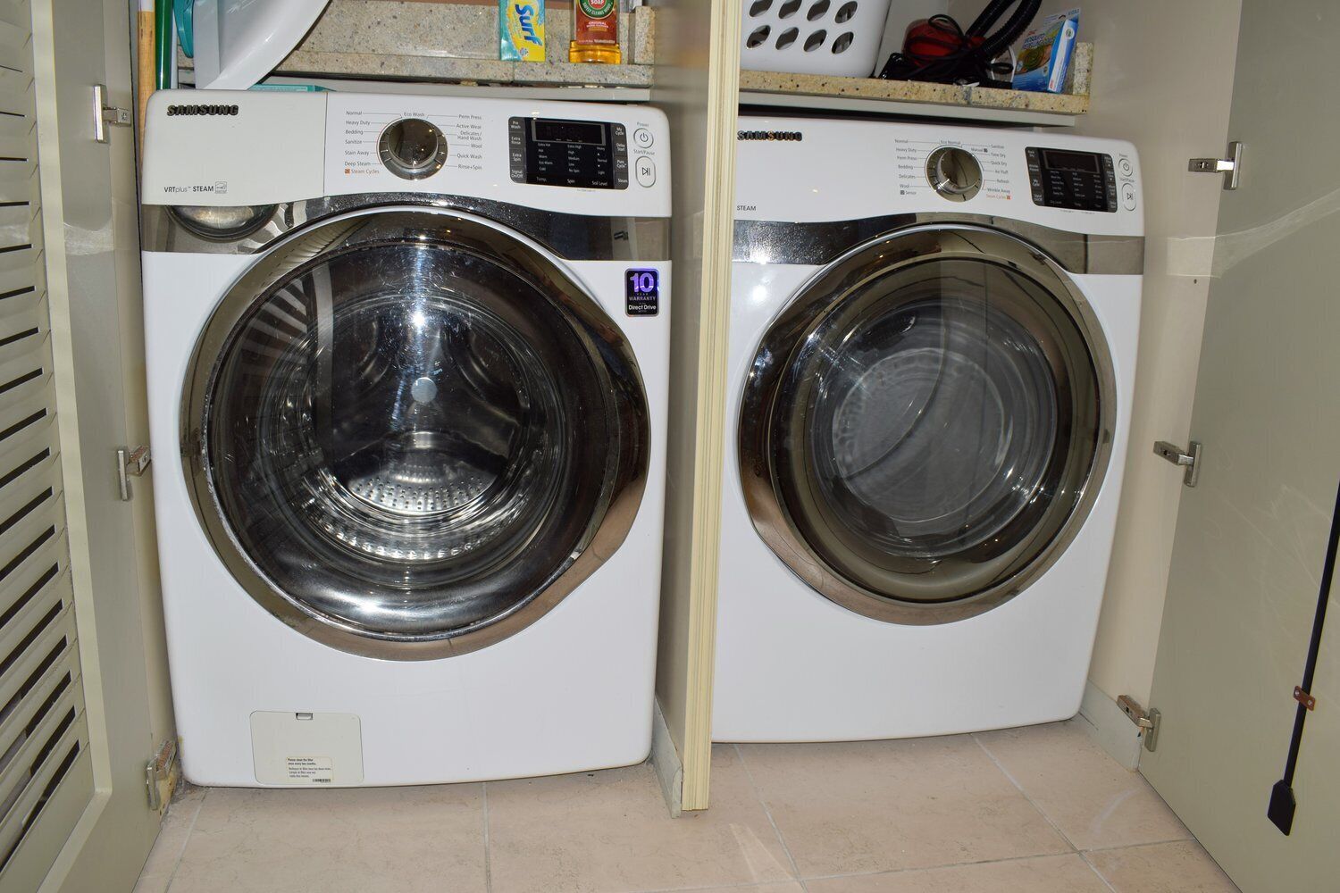 A compact, white front-loading washer and dryer unit with a control panel and a 10-year warranty sticker.