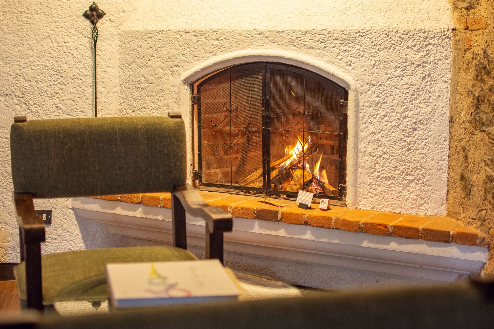 A fireplace with a brick surround and a white textured wall.