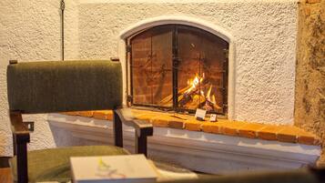 A fireplace with a brick surround and a white textured wall.