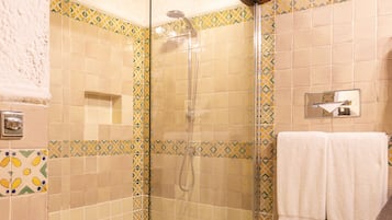 A shower with a glass door, tiled walls, and a wooden ceiling.