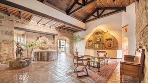 A spacious hall with stone walls, a wooden ceiling, and a large ornate altar. - Hotel Museo Spa Casa Santo Domingo (Antigua Guatemala)